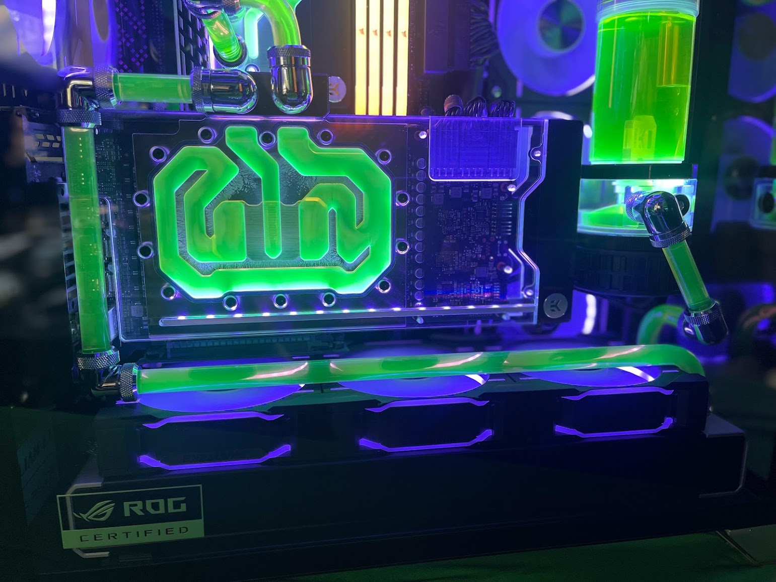 Close view of Dan's water-cooled graphics card, green hardline tubes and pump reservoir