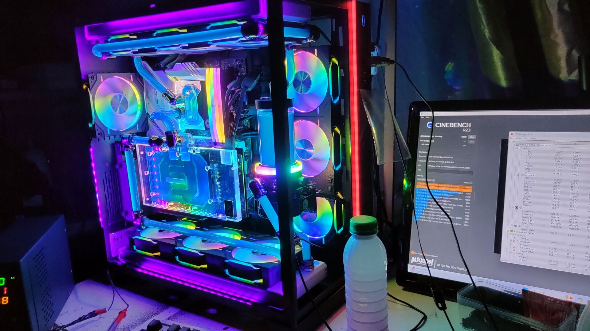 Edmond's completed custom water-cooled PC beside a monitor during build testing