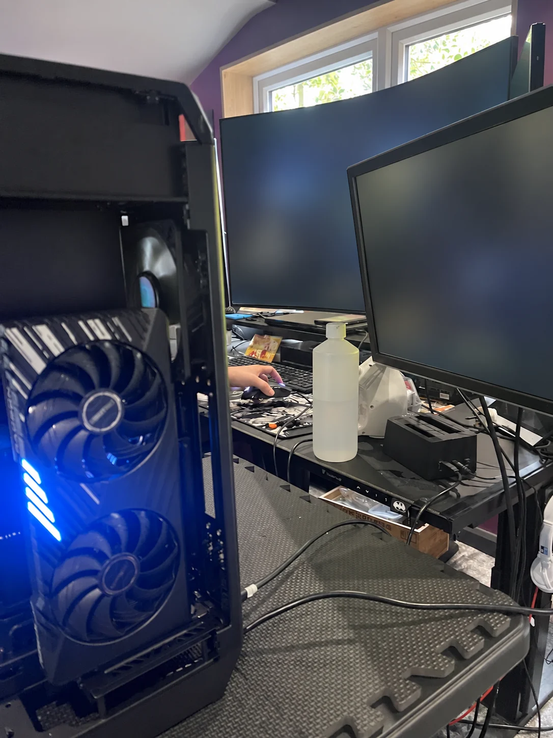 Jamie's actual NCore 100 Max PC open on the workshop bench during fan work, with Marcel's hand at the mouse