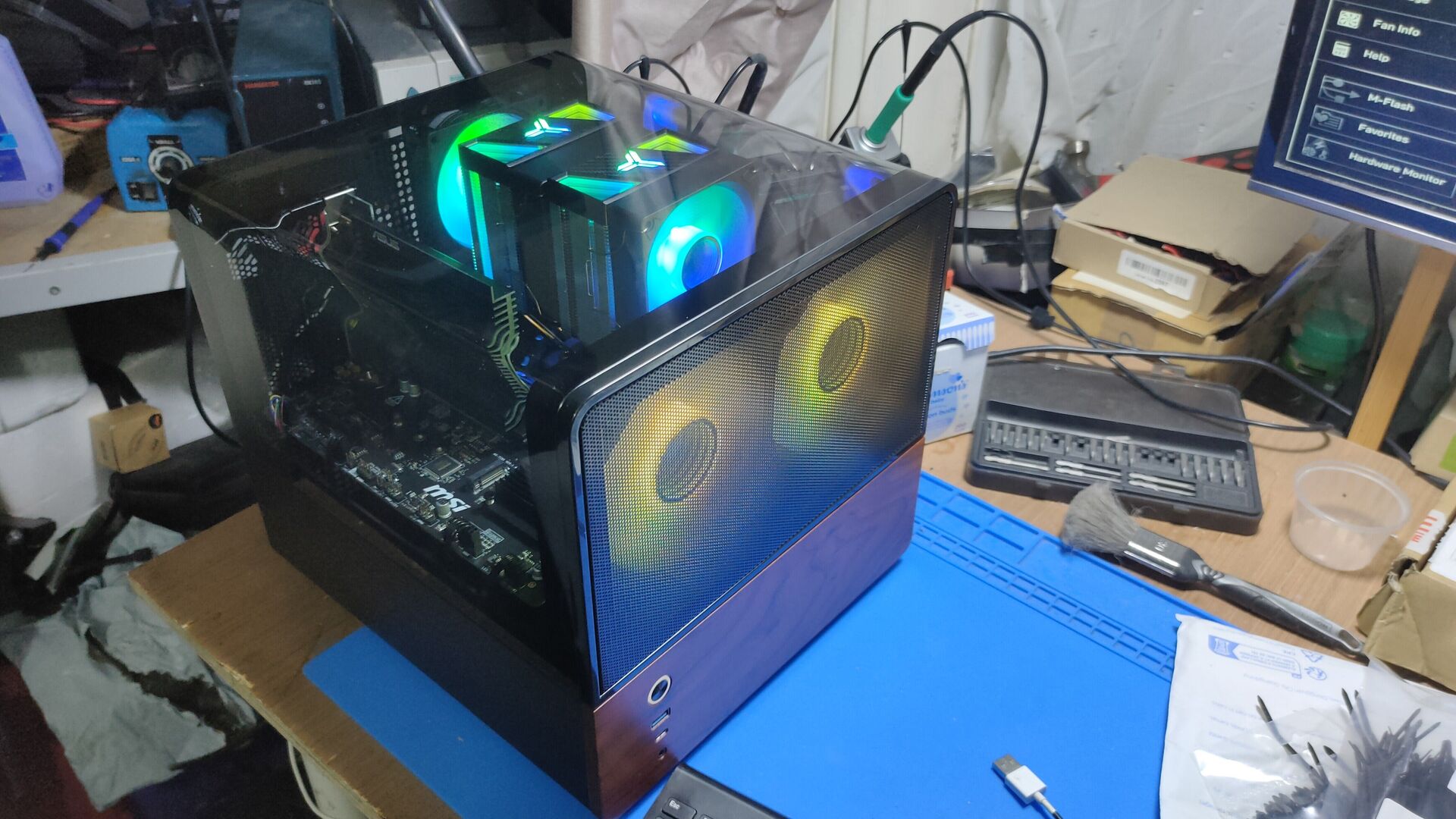 Second unedited workshop view showing Mark's Jonsbo V12 front fans, wood-tone panel and dual-tower cooler